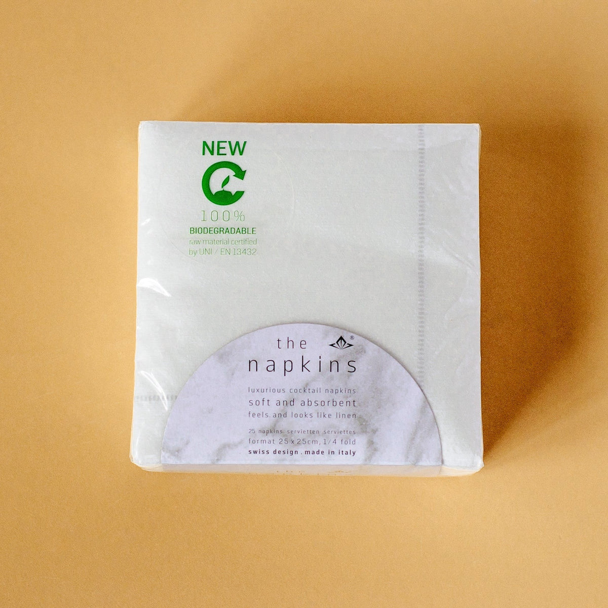 Overhead view of a package of white with gray hemstitch disposable bamboo cocktail napkins.