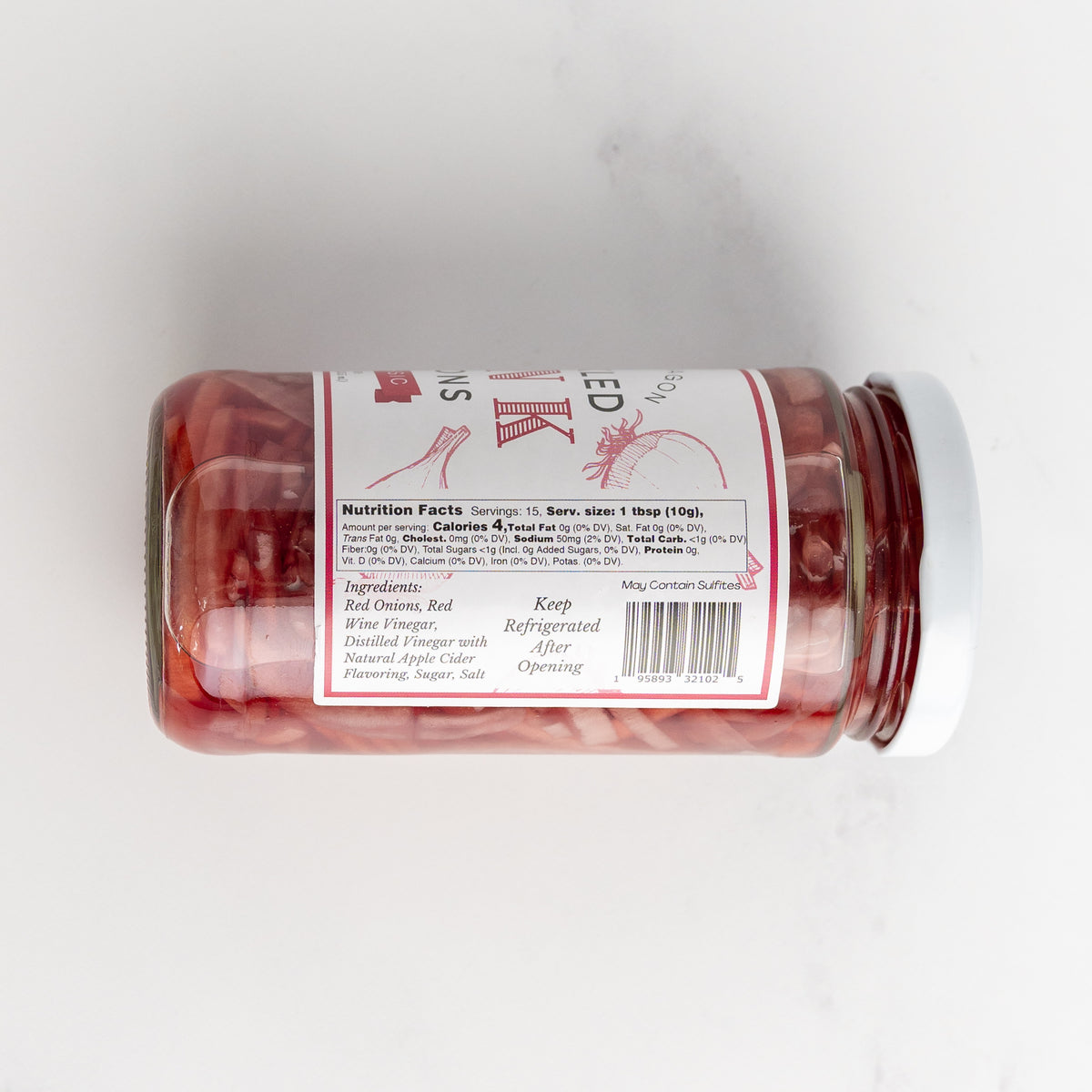 the contents label of a jar of pickled red onions, laying on its side on a marble counter.