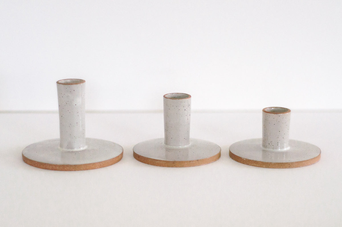 Three sizes of modern minimal ceramic taper candle holders, shown in colorway Ivory. Items sold as singles to be mixed and matched.